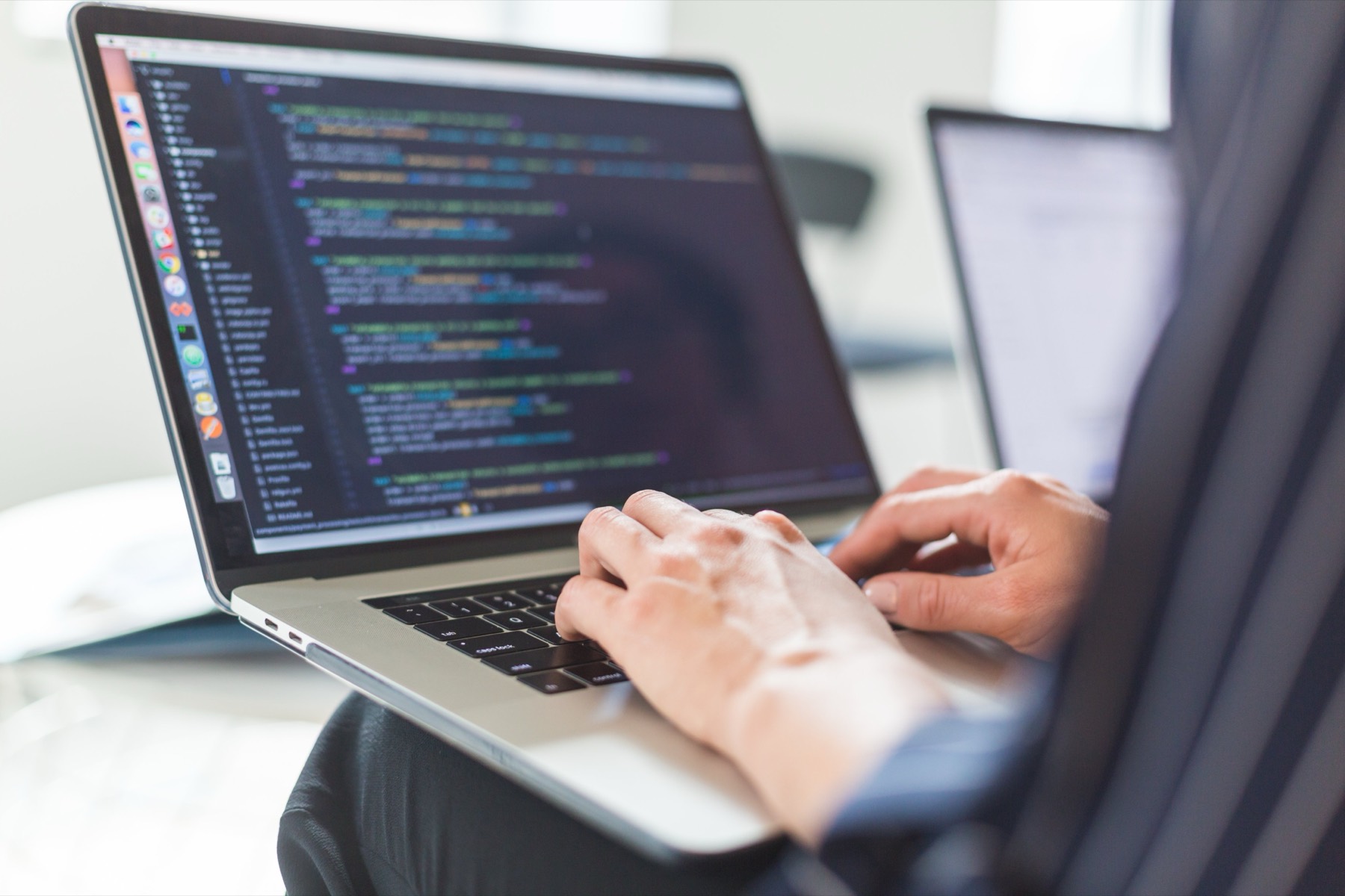 Developer writing code on a laptop